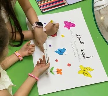 أطفال يشاركون في رسم جماعي ضمن الأنشطة الفنية